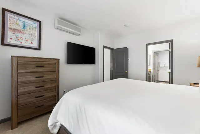 King bedroom with dresser and wall-mounted TV