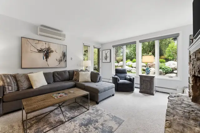 Living room seating with garden-view windows in the Arrowhead condo